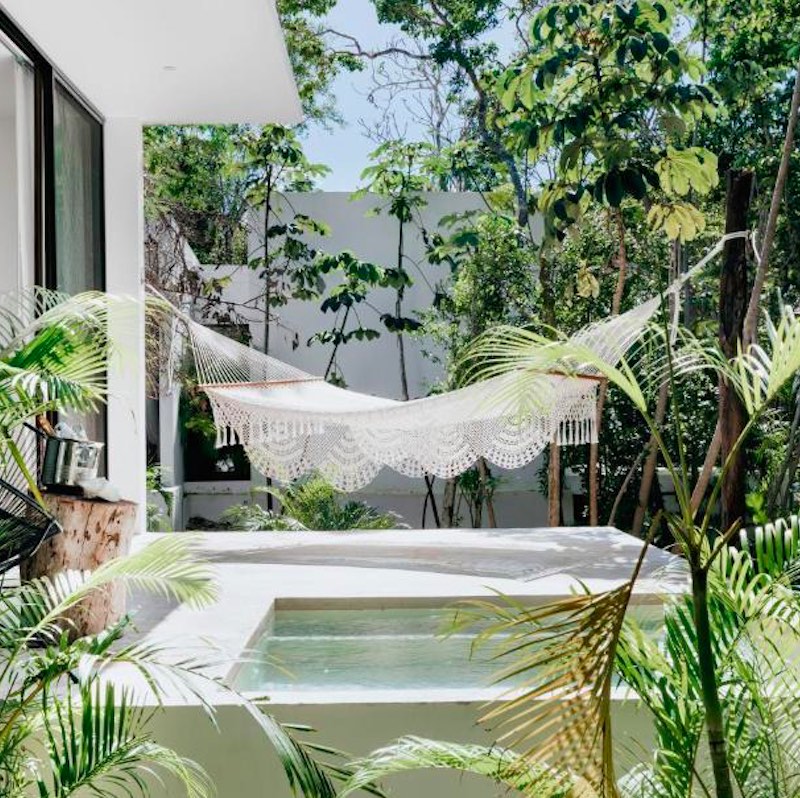 outdoor terrace with small private pool surrounded by palm trees and a hammock at the Jungle Lodge Boutique Hotel in Riviera Maya.