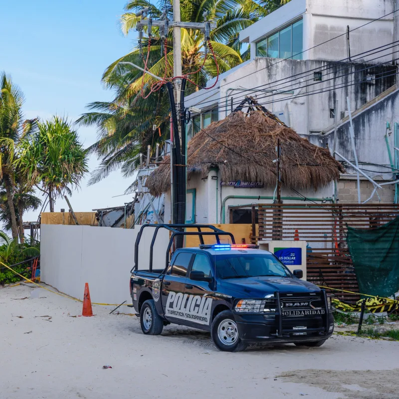 Police car Tulum near the beach parked on the side of the road.