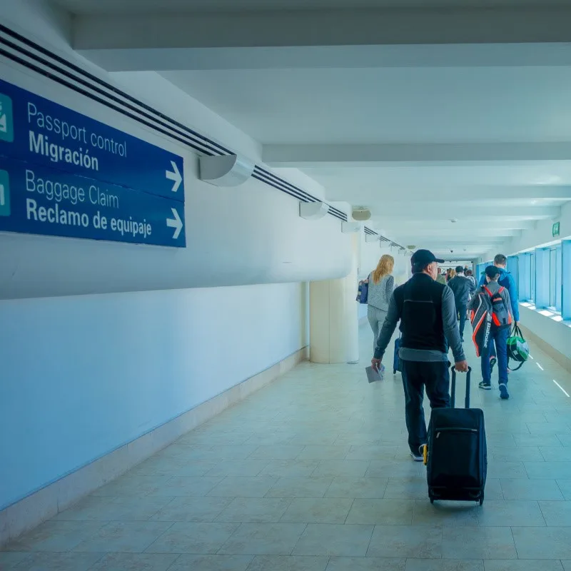 Tourists Walking down a hallway to Baggage Claim at Cancun International Airport