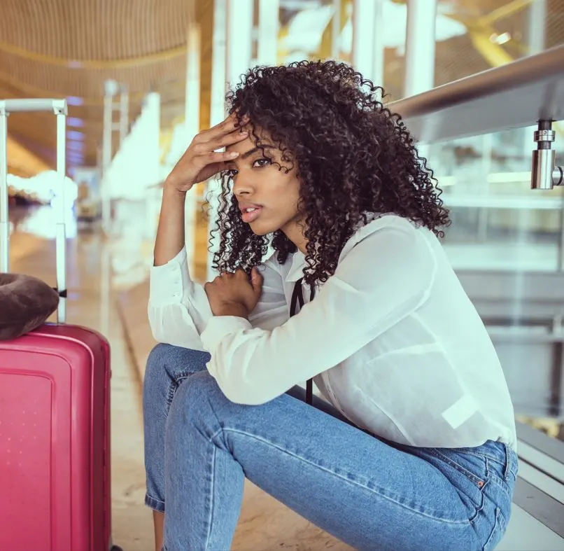 black-Woman-sad-and-unhappy-at-the-airport-with-luggage