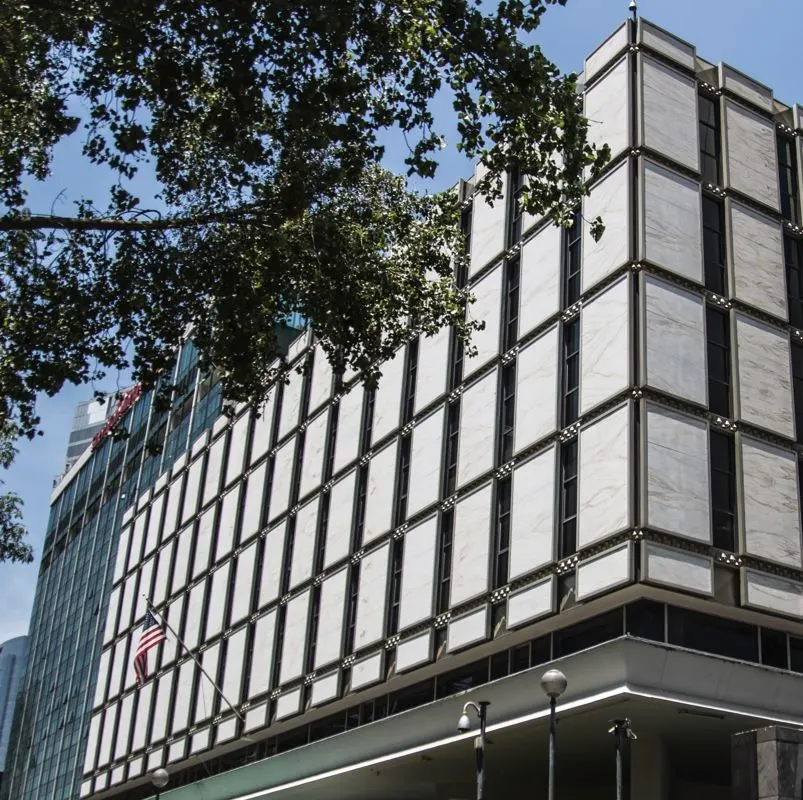 building of United States Embassy in Mexico with American flag floating on sunny day