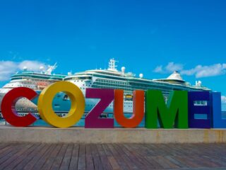 Cozumel colorful sign cruise ship on sea in the back