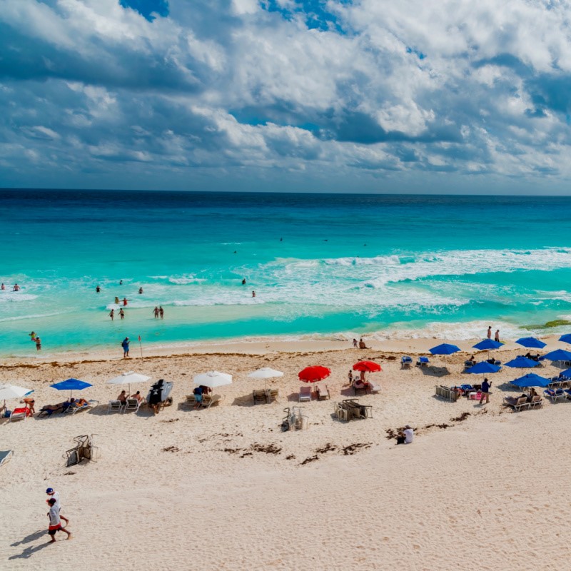 Beautiful Cancun Beach Surrounded by Turquoise Blue Water and Filled With Tourists.