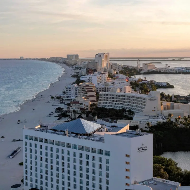 Cancun Hotel Zone with a view of various resorts, beaches, and the Caribbean Sea at sunset.