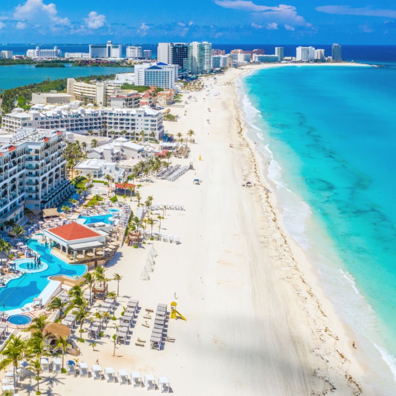 Cancun Hotel Zone with beautiful Mexican Caribbean waters and white sand beaches with hotels in the background.