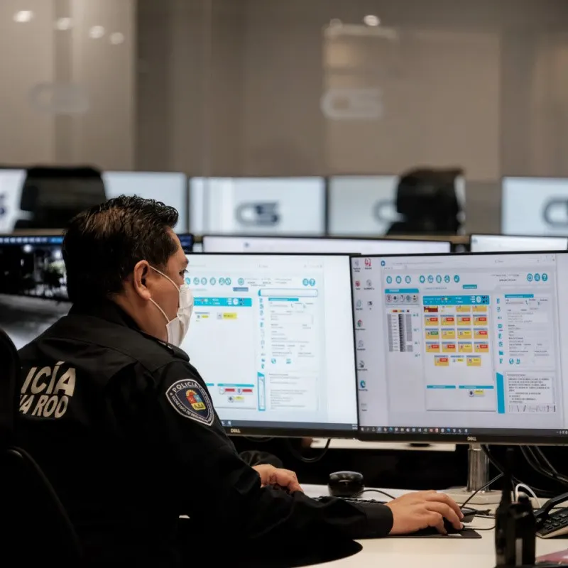 Cancun Police Officer Monitoring Security on a computer.