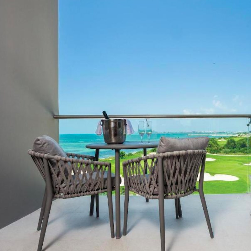 table set overlooking the Caribbean on a hotel room patio at the Dreams Vista Cancun All Inclusive Resort.