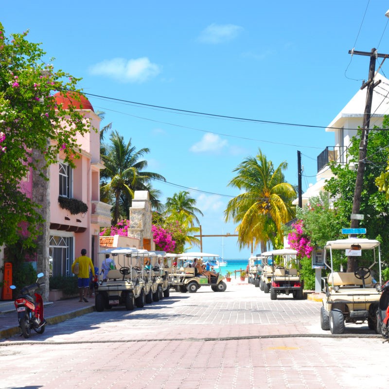 Golf Carts on a Street Leading Up to the Caribbean Sea in Isla Mujeres.