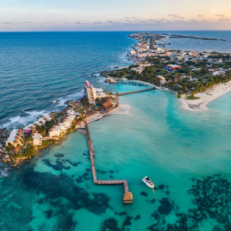 View of Isla Mujeres and Cancun surrounded by turquoise blue waters and white sand beaches.