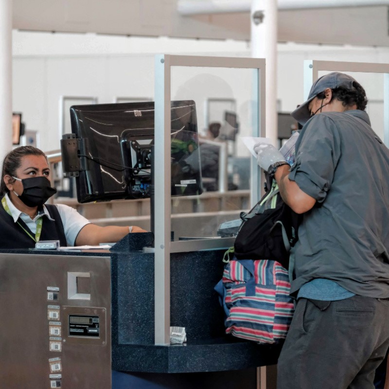 Man Going Through Security in Cancun with a woman checking a monitor.