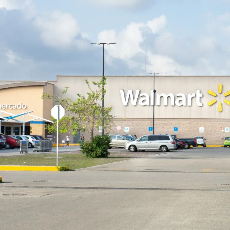 Playa del Carmen Walmart with cars in the parking lot and the Walmart sign in view.