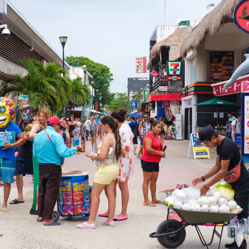 Busy street in Playa del Carmen with shops and lots of tourists