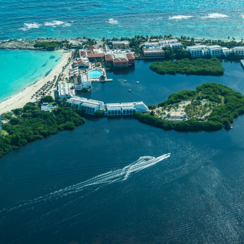 Aerial View of Cancun with a View of Beaches, Trees, and a Boat in the Water.