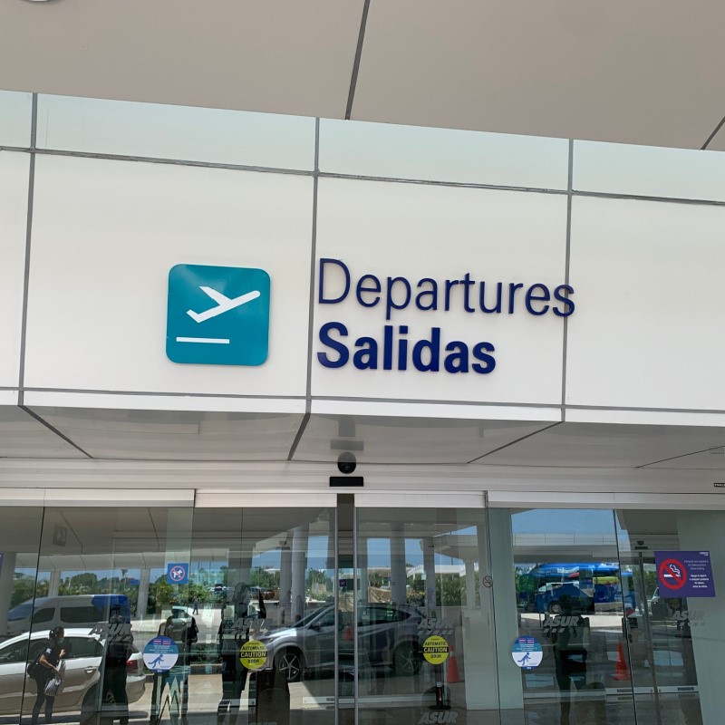 Cancun Airport Departures Entrance with reflections of people in the windows.