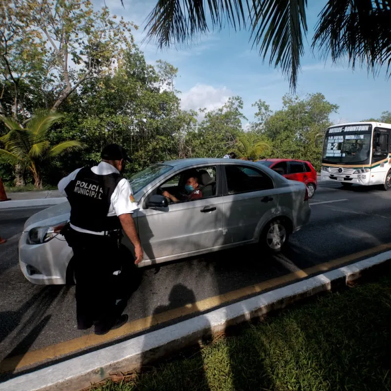 Municipal Police in Cancun Hotel Zone with cars on the road.