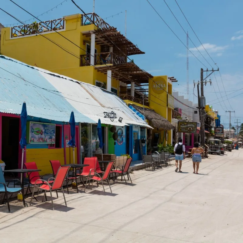 Tourists Walking Down the Street in Holbox in front of restaurants.