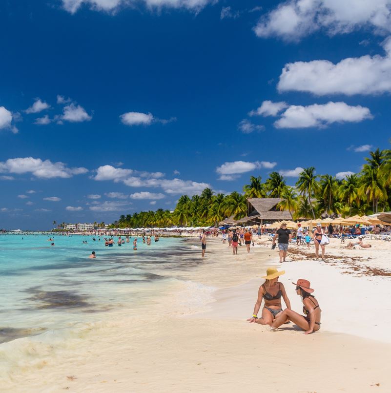 Tourists on a cancun beach enjoying the sunshine, ocean, and sand