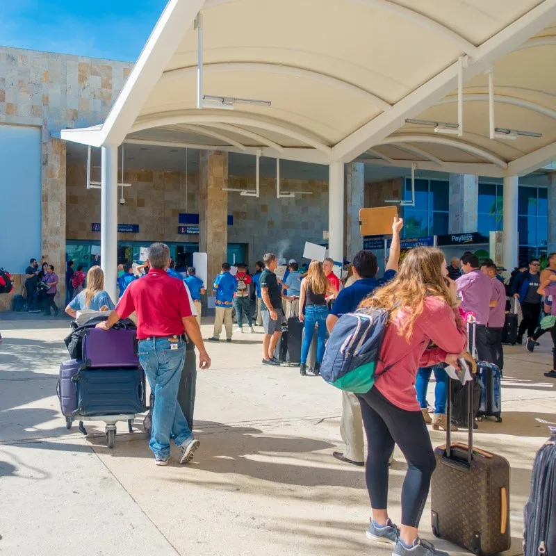 Tourists with Luggage at Cancun International Airport, waiting to be picked up and brought to their hotels.