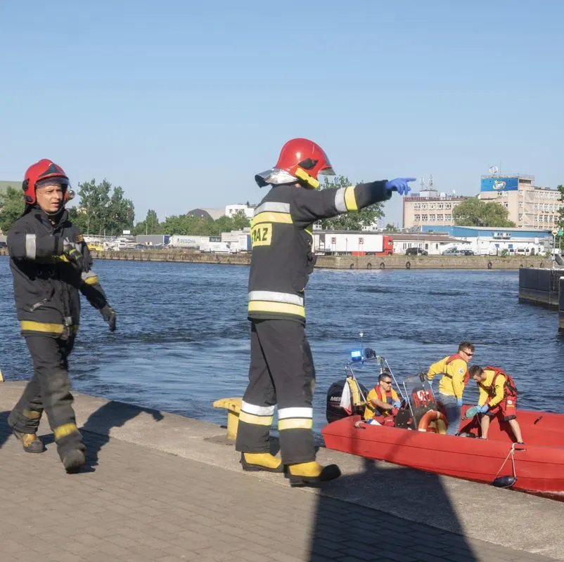 a group of medical professionals during a rescue operation after drowning individual in a body of water. clear skies