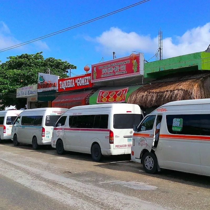 colectivos parked on the side of a main street in Quintana Roo, Mexico.