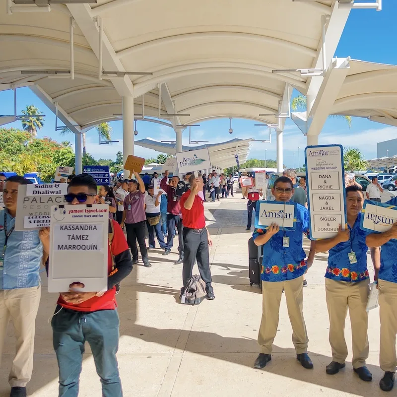 Transportation Drivers at Cancun Airport Holding Signs with Passenger Names