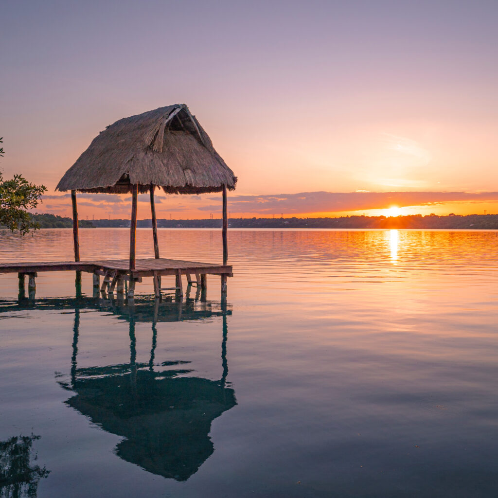Bacalar lagoon and pier with palapa at sunset in Quintana Roo, Mexico.