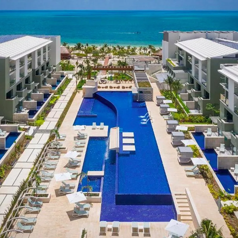 aerial view of the Catalonia Grand Costa Mujeres swim up pools and outdoor pool, Caribbean Sea in the background.