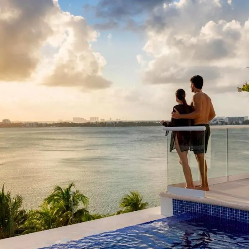 couple standing up a swim up pool at the Hyatt Zilara Cancun looking out at the Caribbean Sea.