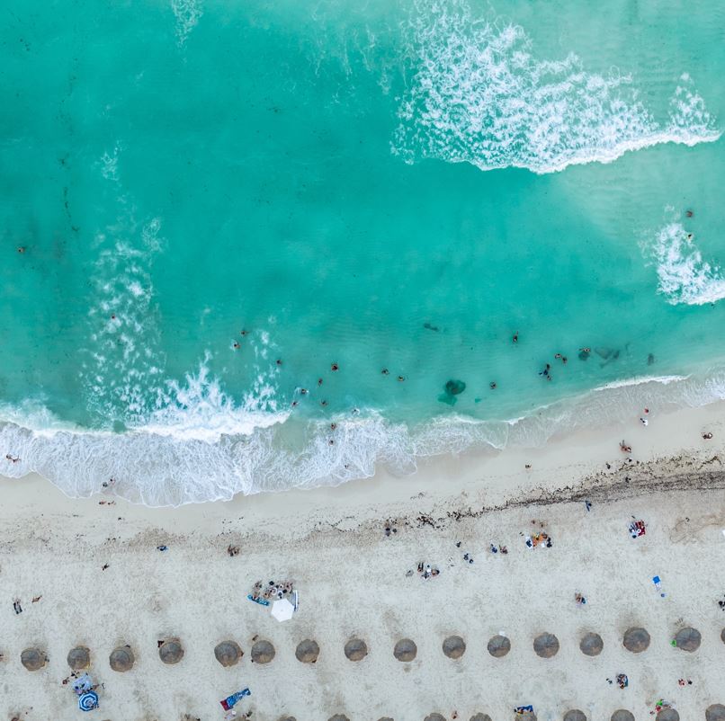 Overhead view of a beach in cancun with people in the sand and the water