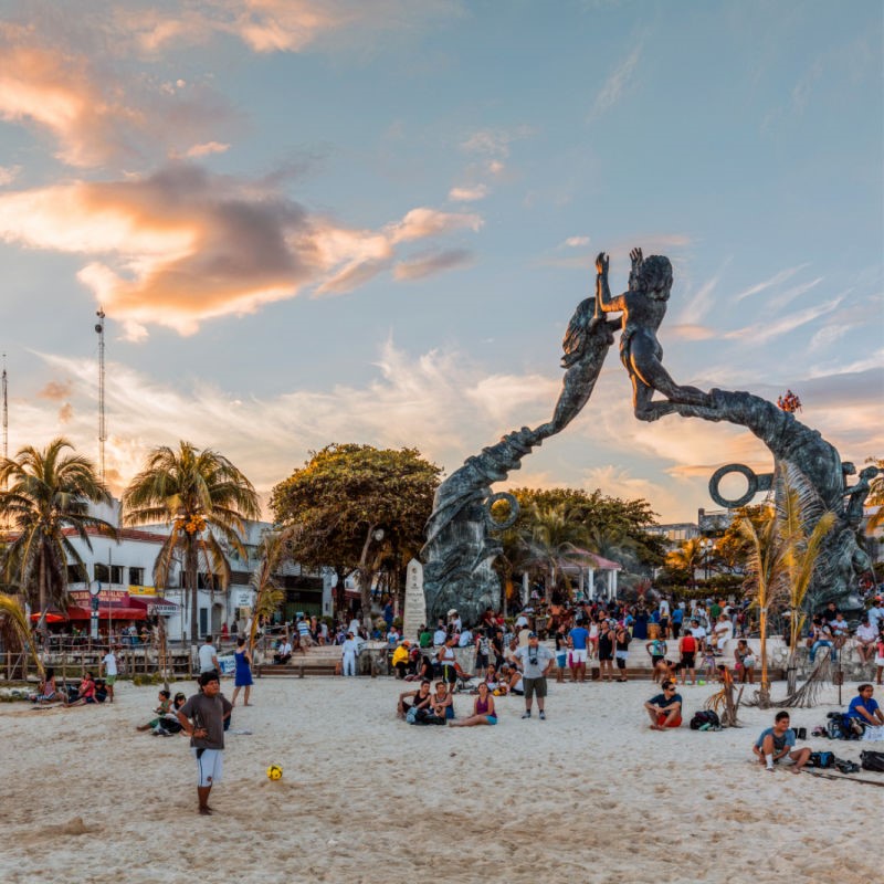 People on the Beach Near the Playa del Carmen Sculpture at Sunset