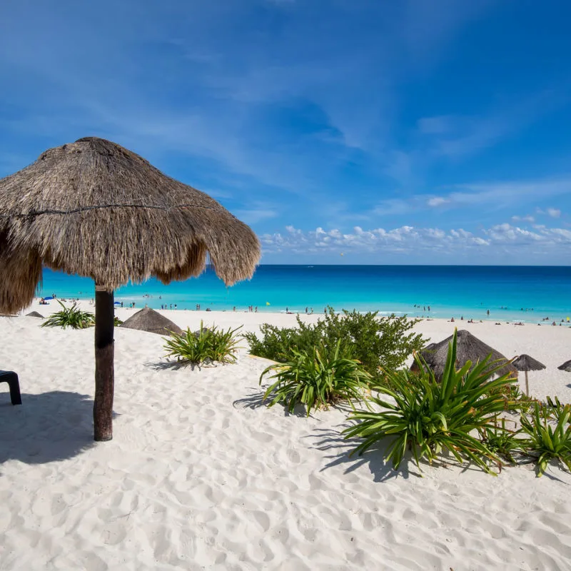 Playa Deflines in Cancun with a straw parasol and beautiful water