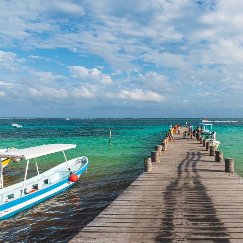 Small People Walking Along a Puerto Morelos Dock and Boats in the Water