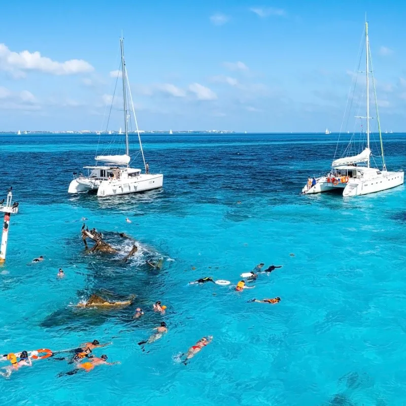 People in the Water Snorkeling Near Yachts in Cancun