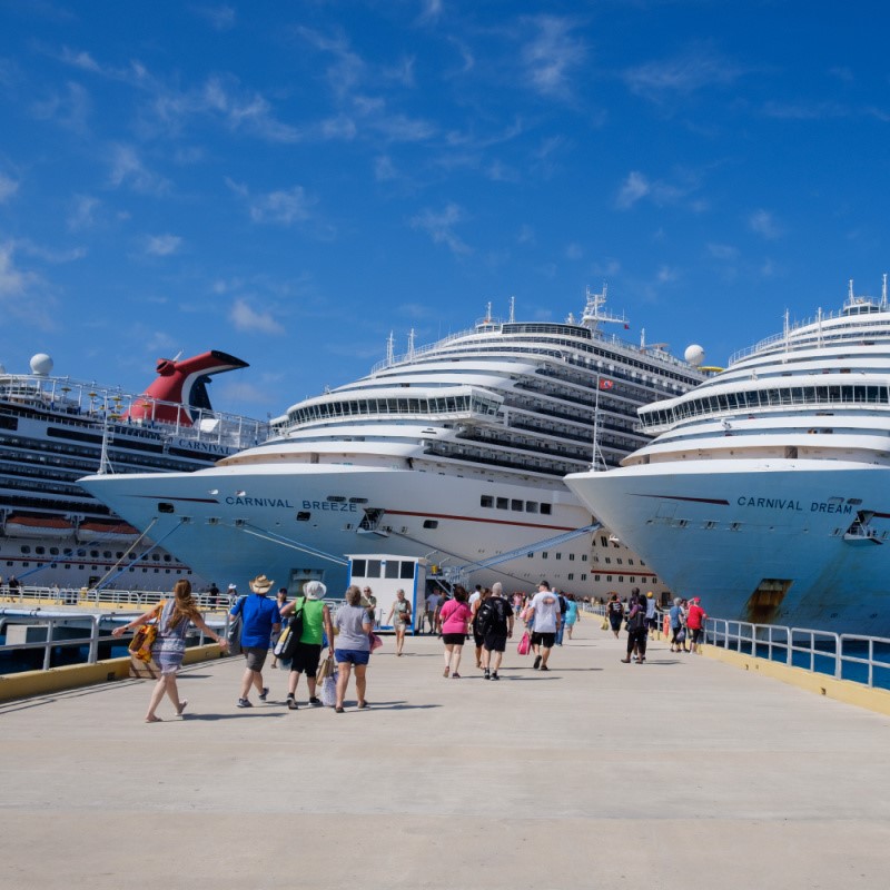 Three Carnival Cruise Ships in Cozumel, Mexico with Tourists Walking Around