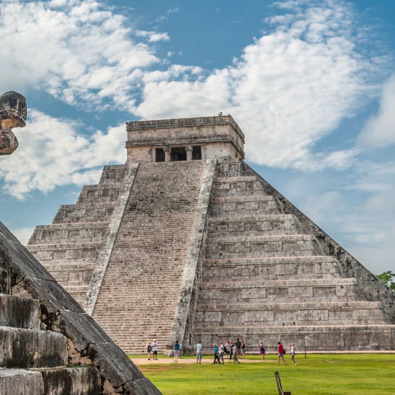 Tourists are looking at the ruins of Chichen Itza