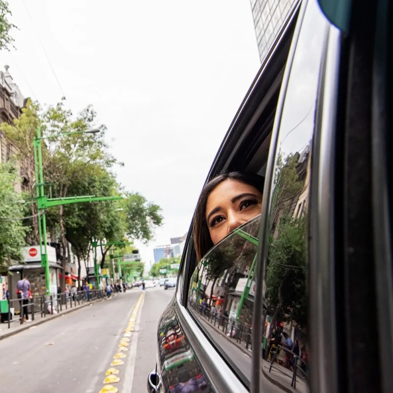 Woman in a Vehicle Driving Down a City Street