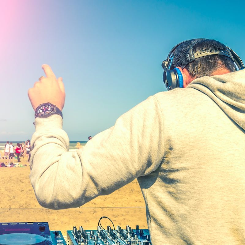 Dj playing music at a beach party.