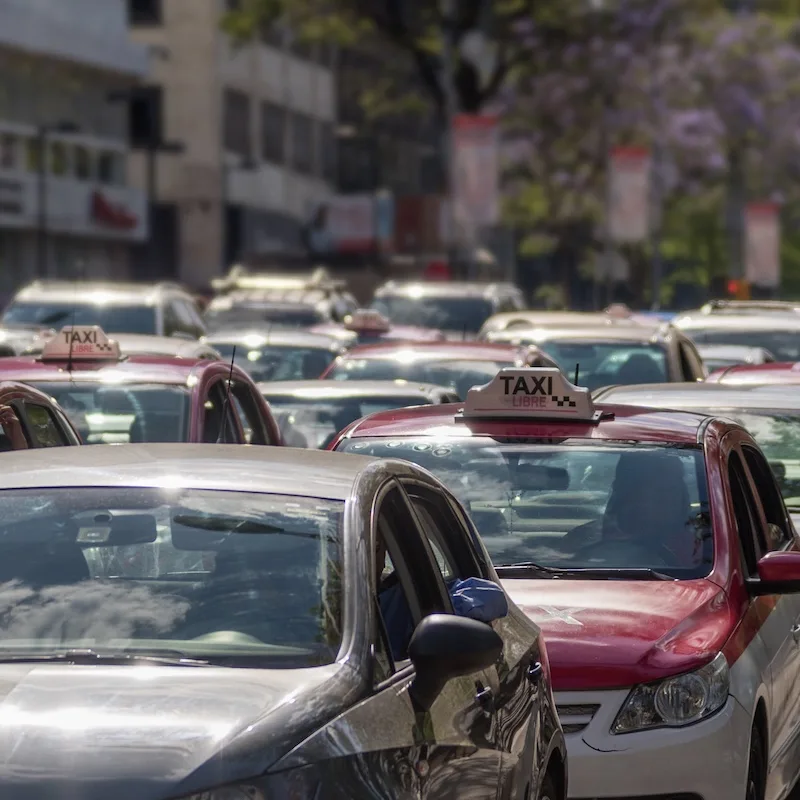 Busy traffic in Mexico with taxis in the traffic with other vehicles.