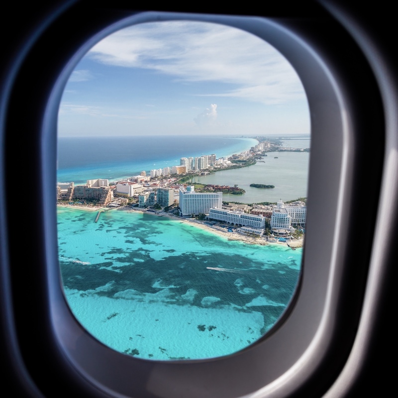 view from an airplane landing in Cancun with resorts and ocean 
