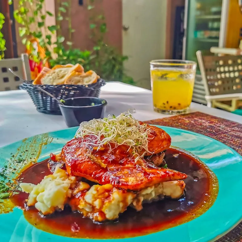 plate of delicious looking Mexican food and a glass of passionfruit juice in the background.