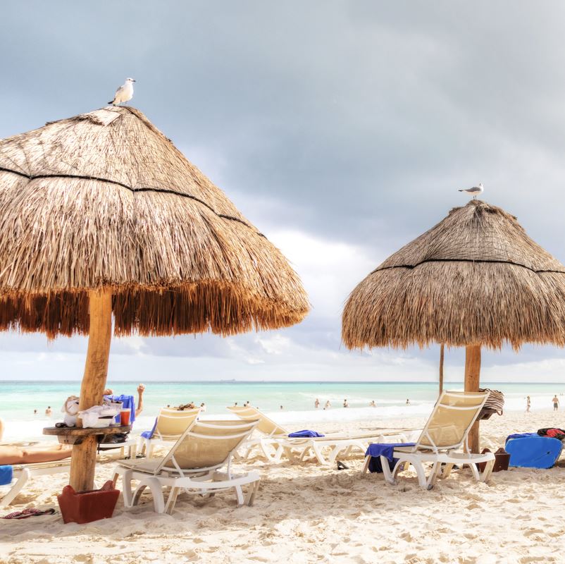 tiki umbrellas on a cancun beach