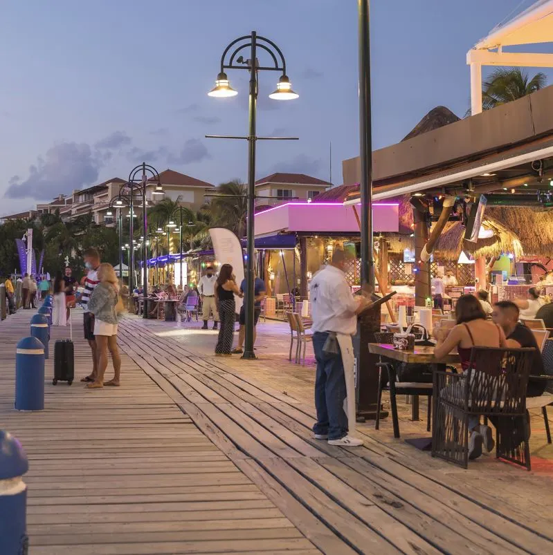 tourists eating dinner outside on pier in cancun