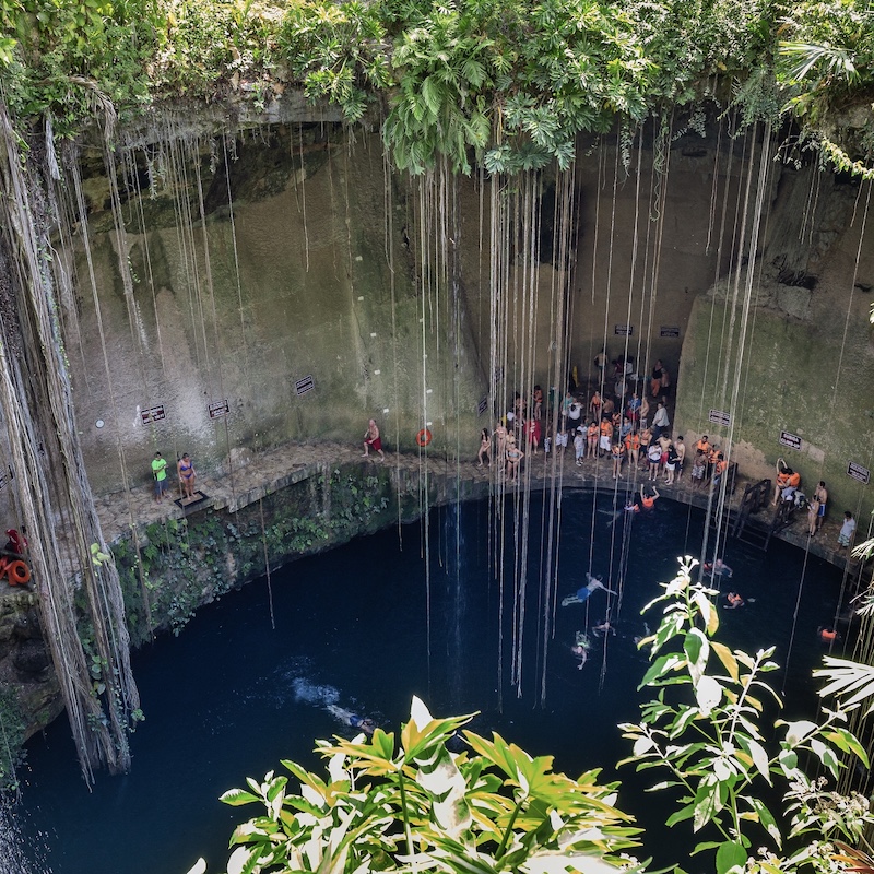 travelers swimming in chichen itza cenote