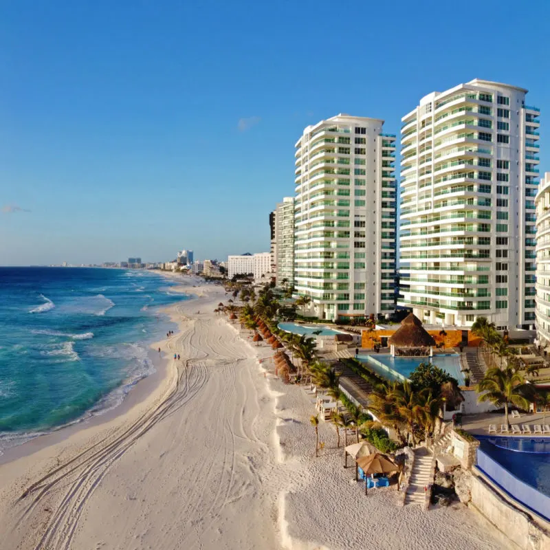 Cancun resorts with a white sand beach and travelers 