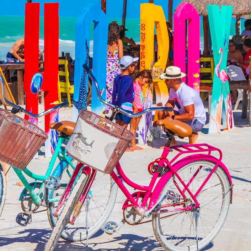 Colorful welcome letters and sign on the beautiful Holbox island sandbank and beach with waves turquoise water and blue sky in Quintana Roo Mexico.