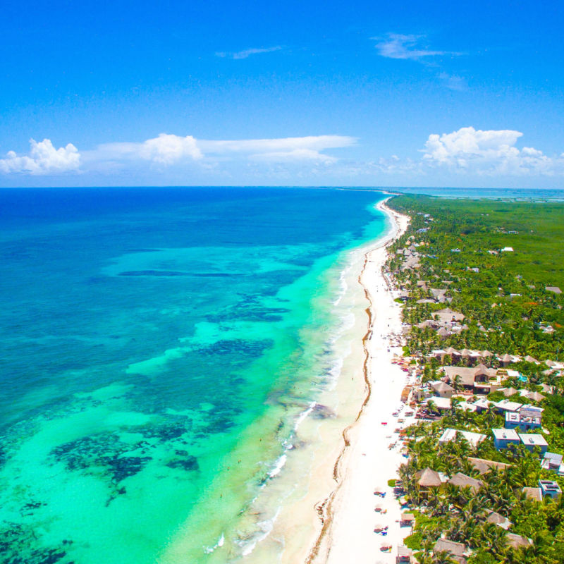 Tulum's long coastline with tropical forest and blue water