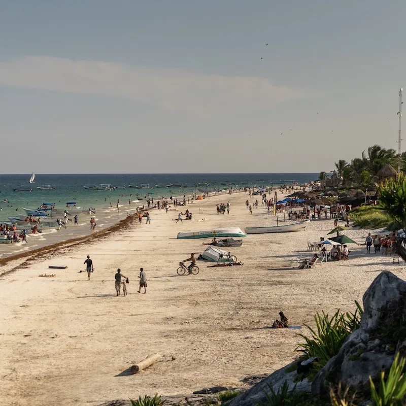 A Tulum beach full of beachgoers and travellers 