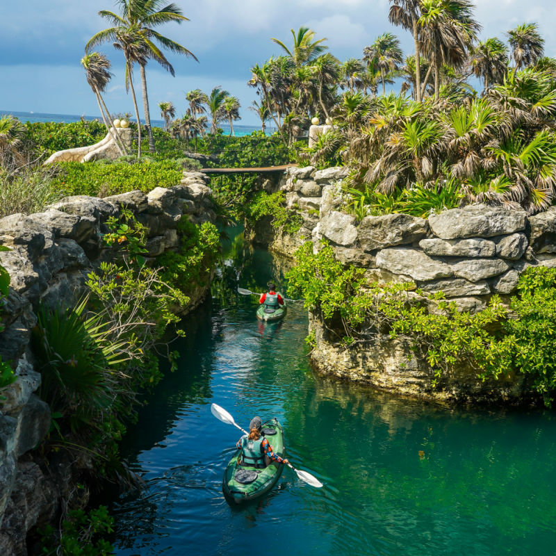 An outdoor view of Xcaret Park with a couple kayaking