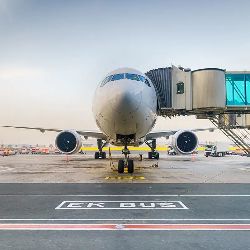 Airplane on a runway with bridge attached