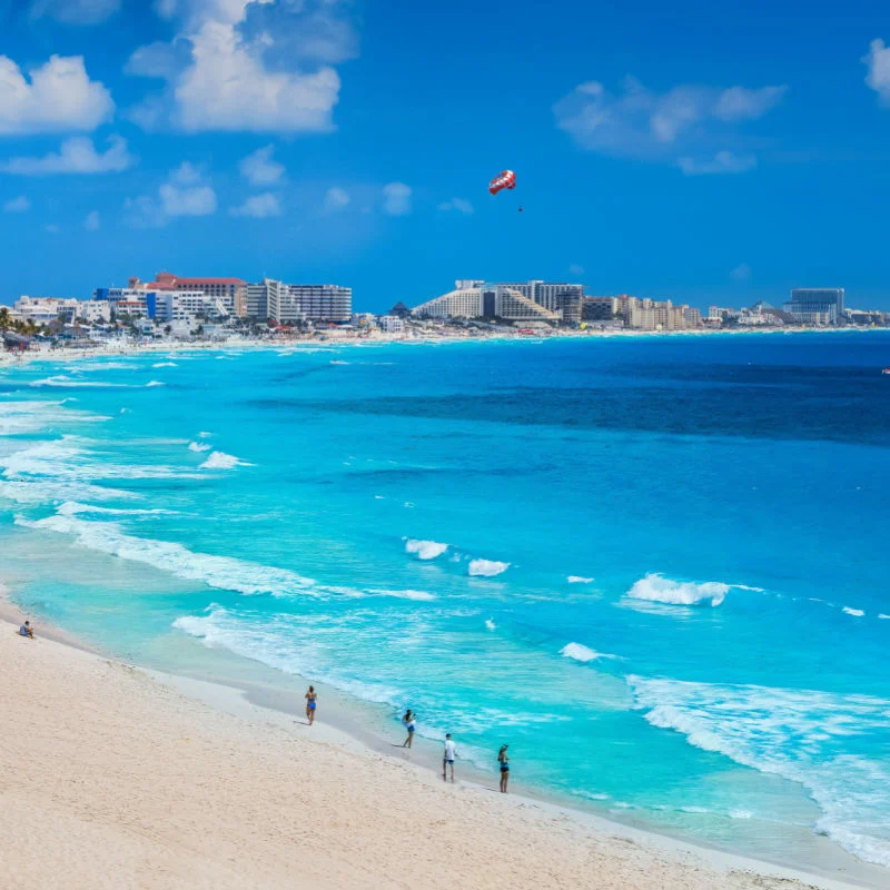 Blue water in a Cancun beach with travelers